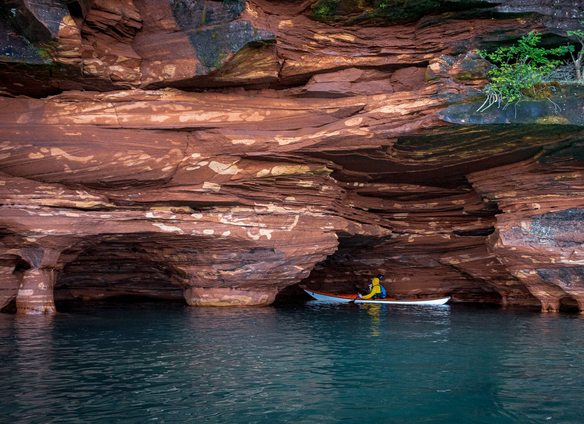 kayaker explores the sea caves of sand island in the apostle islands national lakeshore, a four hour drive from Minneapolis