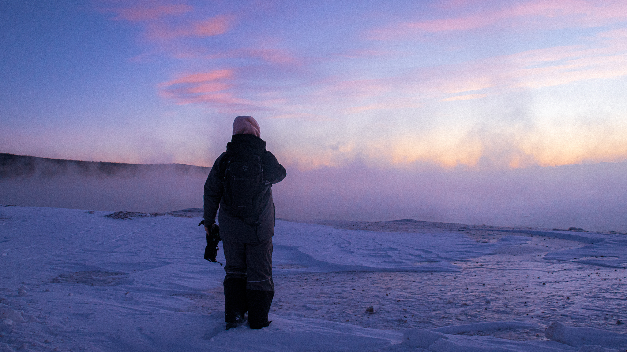 image of a hiker in a snowsuit on the edge of a wintery lake superior