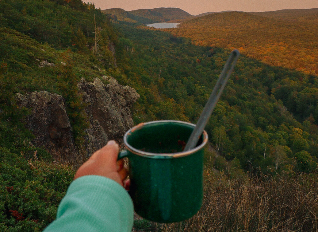 Image of a campsite in the porcupine mountains with a cup of coffee in front of a stunning overlook