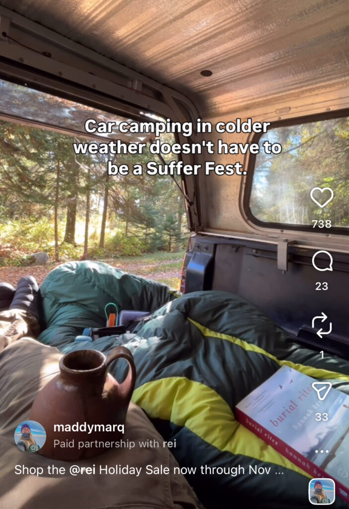 Screenshot of a sponsored instagram reel with REI by @maddymarq featuring the inside of a camper truck set up in the woods